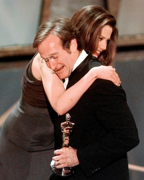 Robin Williams hugs presenter Mira Sorvino after he won Best Supporting Actor for his role in "Good Will Hunting" at the 70th Academy Awards in Los Angeles Monday, March 23, 1998. (AP Photo/Susan Sterner)